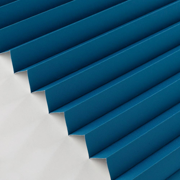 Blaues Plissee mit vertikalen Falten zeigt eine strukturierte Oberfläche. Die Falten sind gleichmäßig angeordnet und das Material wirkt lichtundurchlässig.