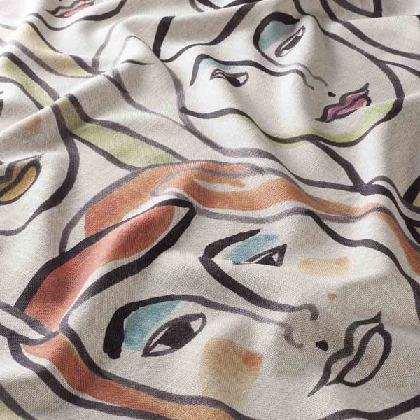Bunte, abstrakte Gesichter und Linien sind auf dem hellen Dekostoff abgebildet. Der Stoff zeigt warme Farbtöne wie Orange, Rosa und Grün.