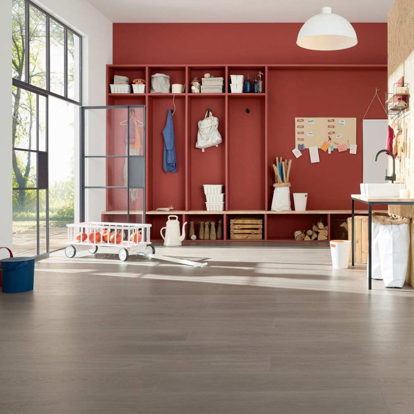 Holzoptik-Vinylboden in hellen, sanften Grautönen wird gleichmäßig verlegt. Der Boden wirkt modern und sorgt für ein stilvolles Ambiente in jedem Raum.