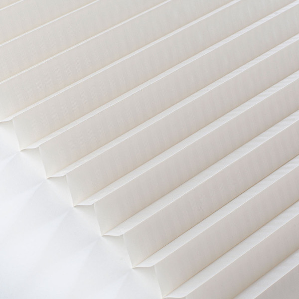 Plissee in Cremefarbe zeigt eine gefaltete Struktur mit gleichmäßigen Falten. Es steht auf einem weißen Hintergrund und verdeutlicht die blickdichte Qualität des Materials.