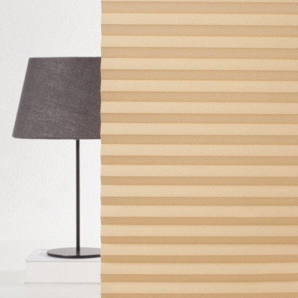 Orangefarbenes Plissee mit gefalteter Struktur liegt flach auf einer Oberfläche. Das Plissee zeigt gleichmäßige Falten und eine sanfte Textur.