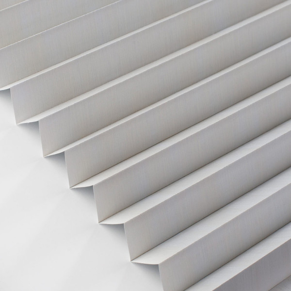 Die Plissees sind in einer ansprechenden, grauen Farbe angeordnet. Die gefalteten Stoffbahnen erzeugen ein strukturiertes Muster und sorgen für eine attraktive Lichtregulierung im Raum.