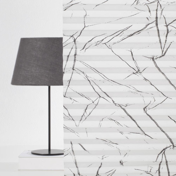 Weißes Plissee mit schwarz-ähnlichen Linien auf der Oberfläche ist faltig angeordnet. Das Licht reflektiert auf den Falten und zeigt die Struktur des Materials.