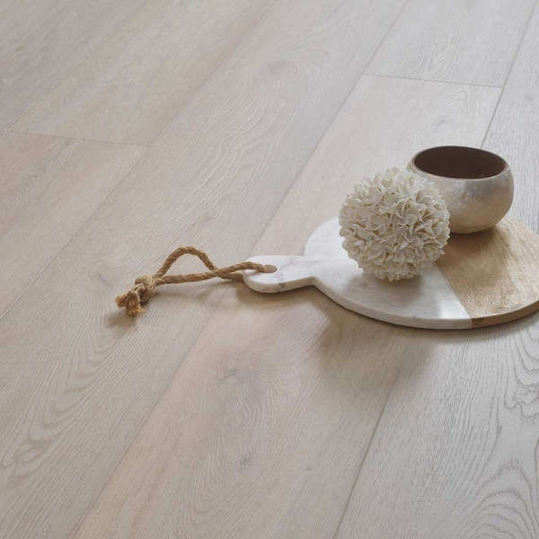 Helle, graue Holzoptik mit feinen Maserungen und Knoten, die den Charakter von natürlichem Holz imitiert. Der Bodenbelag vermittelt eine moderne und elegante Atmosphäre.