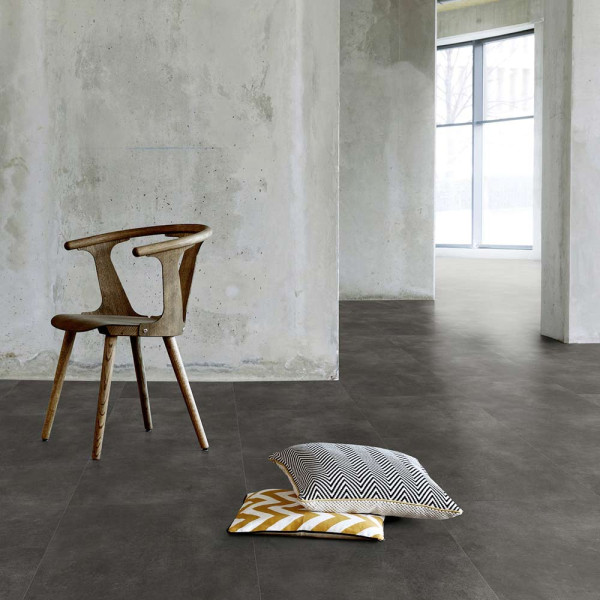 Dunkler Designboden mit einer strukturierten Oberfläche aus Steindekor. Die Platten sind in verschiedenen Größen angeordnet und zeigen eine matte, graue Farbgebung.