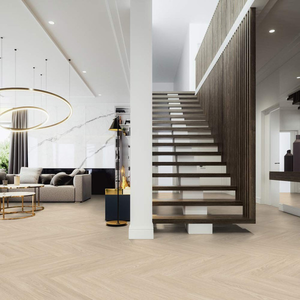 Helle, kreative Verlegeart eines Klebe-Vinylbodens mit einem hellen Holzdekor in Fischgrätenoptik. Die Oberfläche scheint glatt und stilvoll, ideal für moderne Innenräume.