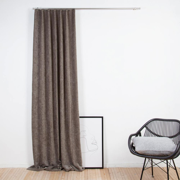 Wärmedämmender Vorhang INUIT aus schwerem Stoff, dunkelbraun mit einer dekorativen Faltenlegung oben, hängt an einer silbernen Gardinenstange.