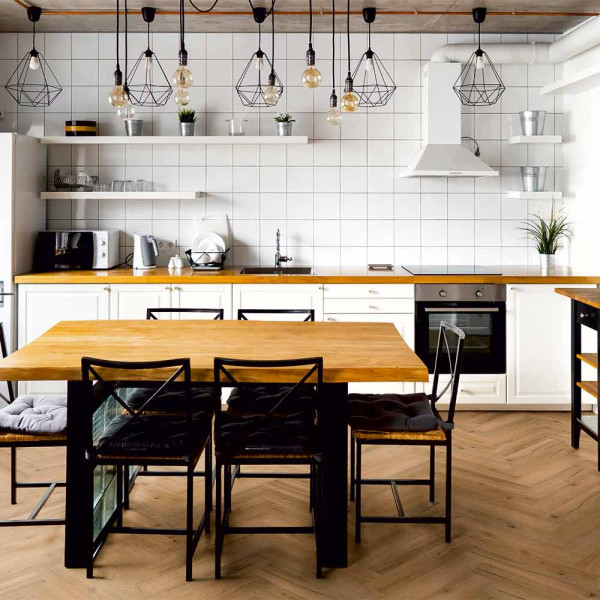 Helle, strukturierte Vinylboden-Planken in einem Fischgrät-Muster aus Nordkap-Eiche. Die Oberfläche zeigt natürliche Holzmaserungen und kleine Unregelmäßigkeiten. Ideal für Wohnräume.