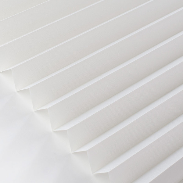 Weißes, halbtransparentes Plissee mit Faltenstruktur liegt auf einem weißen Untergrund. Es zeigt eine elegante und moderne Gestaltung für Fensterdekoration.