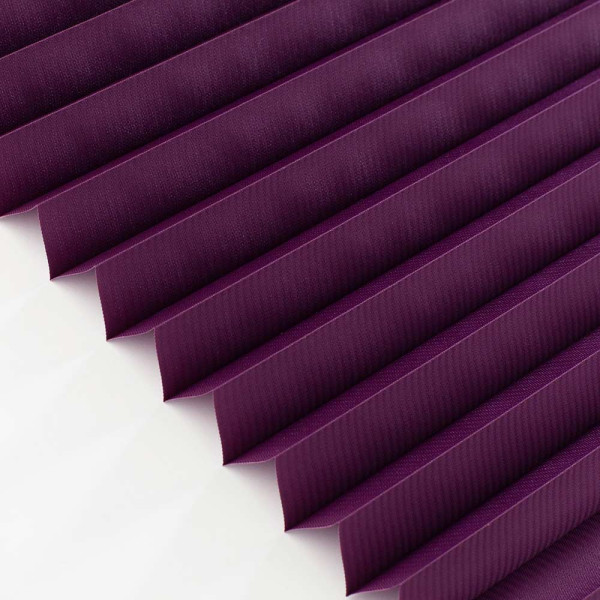 Dunkelviolette Plissee-Jalousien, gefaltet in parallel laufende Rippen, liegen in einem geometrischen Muster nebeneinander und reflektieren das Licht. Sie sind blickdicht und für maßgeschneiderte Lösungen konzipiert.