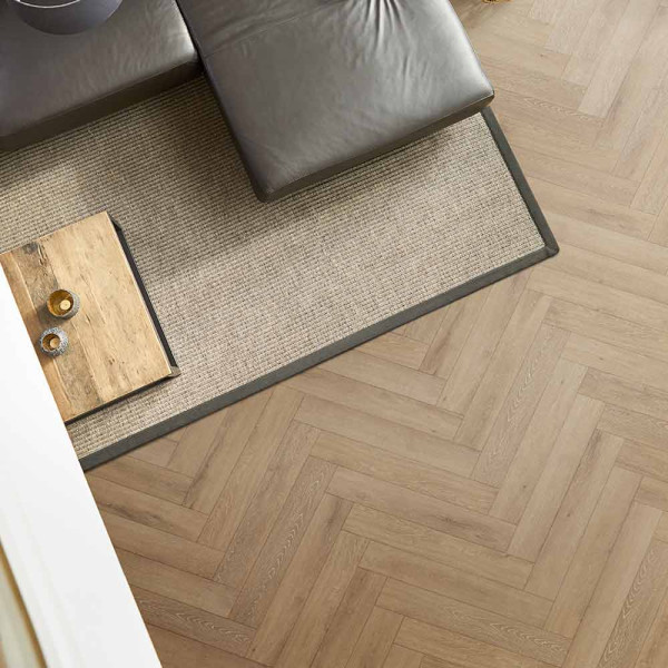 Holzboden mit Fischgrätmuster in hellen Tönen. Die Planken sind in verschiedenen Anordnungen verlegt und vermitteln eine warme Atmosphäre. Ideal für Wohnräume und stilvolle Innenausstattung.