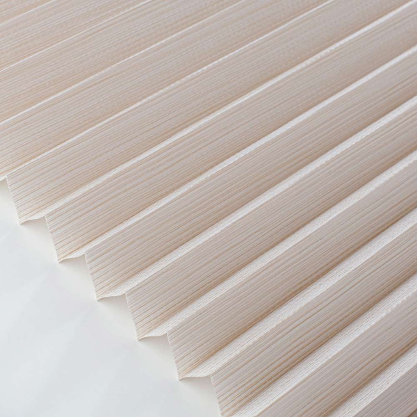 Halbtransparente Plissees in sanften Naturtönen liegen nebeneinander. Die Textur zeigt feine, vertikale Streifen. Diese Plissees sind für maßgeschneiderte Fensterdekoration konzipiert.