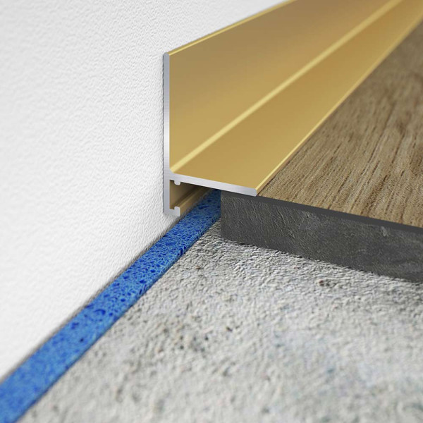 Goldenes Sockelprofil SL 16X5 wird an einer Wandkante montiert. Es verbindet einen Holz- und einen Betonfußboden. Die Höhe beträgt 2,5 cm und die Länge ist 200 cm.