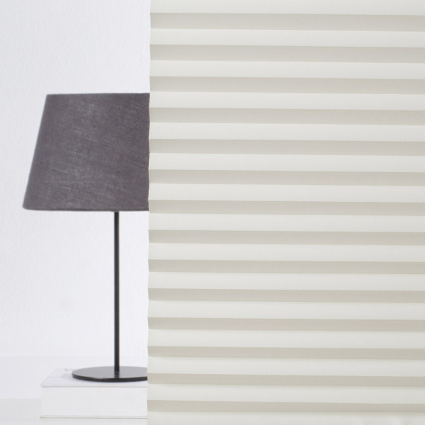 Plissee in Cremefarbe zeigt gefaltetes, blickdichtes Design mit klaren Linien und gleichmäßigen Falten. Es ist für individuelle Maßanfertigungen vorgesehen und könnte als Sonnenschutz dienen.