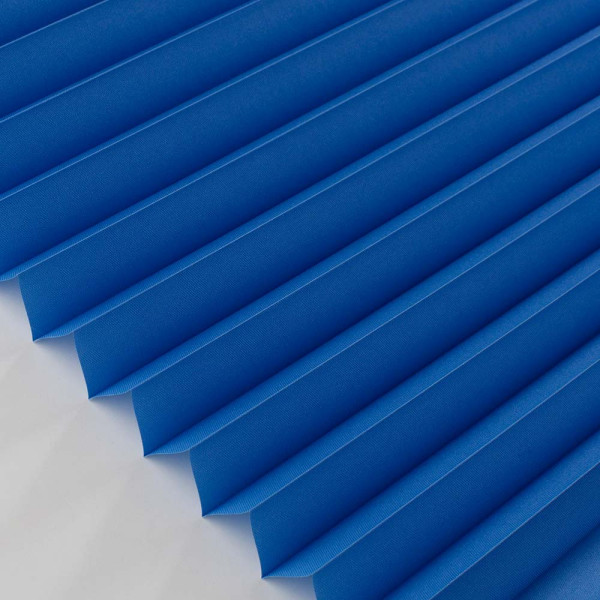 Blaue Plisseestoffbahnen sind in gleichmäßigen Falten angeordnet. Sie zeigen eine strukturierte, blickdichte Oberfläche und sind ideal für maßgeschneiderte Sonnenschutzlösungen.