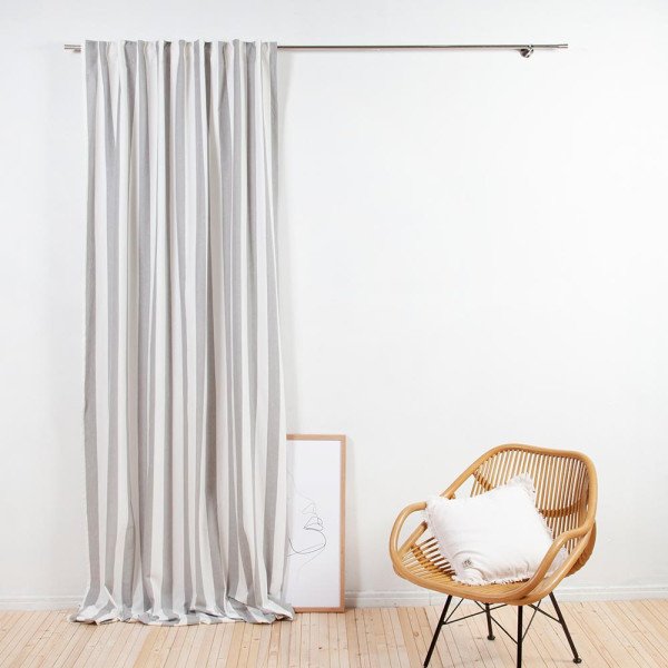 Natürlicher Vorhang in Grau und Weiß mit Streifenmuster hängt an einer silbernen Stange. Der Vorhang sorgt für einen blickdichten Sichtschutz in einem Raum.
