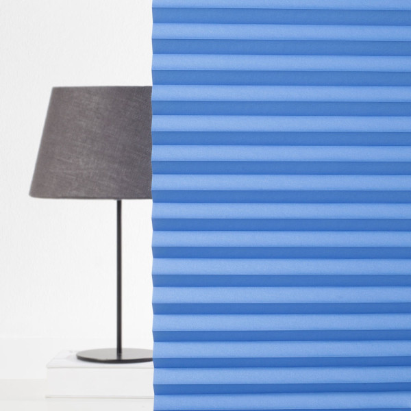 Blaue Plisseestoffbahnen sind in gleichmäßigen Falten angeordnet. Sie zeigen eine strukturierte, blickdichte Oberfläche und sind ideal für maßgeschneiderte Sonnenschutzlösungen.