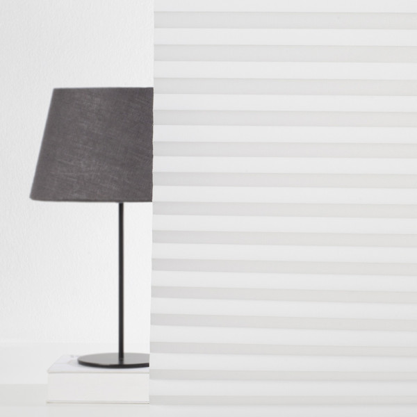 Helle, halbtransparente Plissees aus hochwertigem Material sind gefaltet angeordnet. Sie bieten Sichtschutz und Lichtregulierung und sind nach Maß konfigurierbar. Ideal für Fensterdekoration.