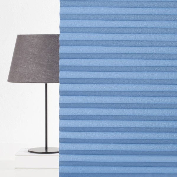 Blaue Plissee-Jalousien mit gefalteter Struktur sind gleichmäßig angeordnet. Die Falten bieten Lichtschutz und Privatsphäre, ideal für individuelle Fensterdekoration.