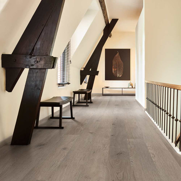 Holzboden mit einer hellen, natürlichen Optik und sichtbaren Maserungen. Die Struktur zeigt verschiedene Brauntöne und kleine Äste, die das Material authentisch wirken lassen.