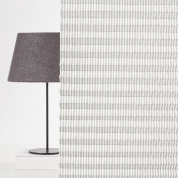 Grau-gestreiftes Plissee mit gleichmäßigen Falten, das in einem hellen Raum platziert ist. Es bietet Sichtschutz und ist auf Maß gefertigt.