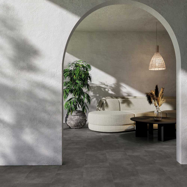 Dunkler Designboden mit einer strukturierten Oberfläche aus Steindekor. Die Platten sind in verschiedenen Größen angeordnet und zeigen eine matte, graue Farbgebung.