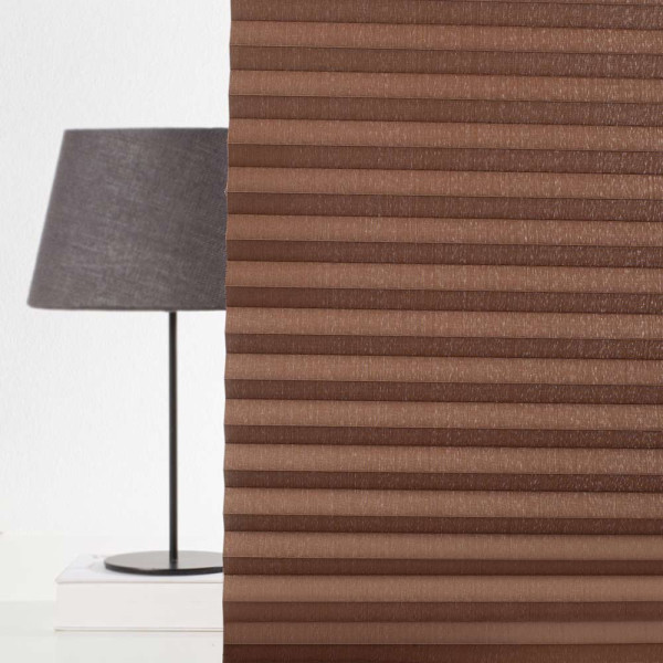 Braunes Plissee Poel 9201 mit sichtbarer Faltenstruktur wird zur Fensterdekoration verwendet. Es bietet eine halbtransparente Eigenschaft und ermöglicht somit kontrollierte Lichtverhältnisse.