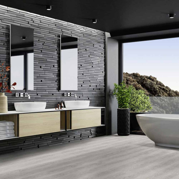 Grauer Klebe-Vinylboden mit Holzoptik zeigt eine feine Maserung. Der Bodenbelag hat eine helle, zeitgemäße Farbgebung und verleiht einem Raum modernistische Eleganz.