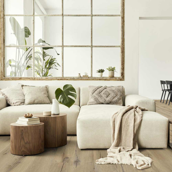 Helle, strukturierte Bodenfläche aus hellem Holzdekor. Die Oberfläche zeigt natürliche Holzmaserungen und Knoten, die dem Designboden eine warme und einladende Wirkung verleihen.