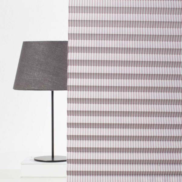 Lila und weiße gestreifte Plissee-Jalousien sind in gleichmäßigen Falten angeordnet. Die Faltenstruktur sorgt für eine elegante Optik. Das Plissee eignet sich zur Verdunkelung und ist nach Maß konfektionierbar.