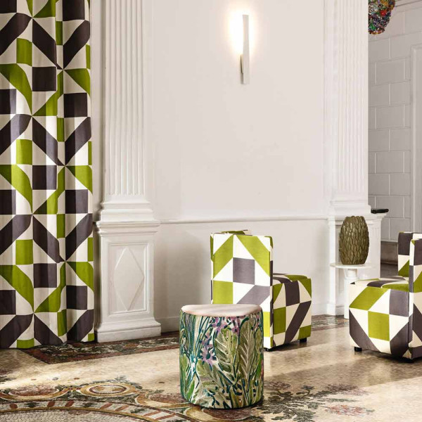 Grüner Vorhangstoff mit Wellenmuster in Grau und Weiß liegt wellig auf einer Oberfläche. Die Struktur und Farbe verleihen dem Stoff eine lebendige Textur.