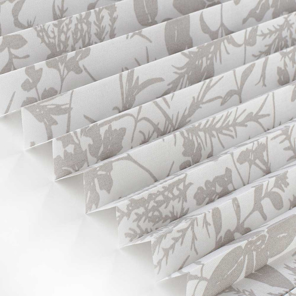 Beige Plissee mit floralen Mustern liegt gefaltet auf einer hellen Oberfläche. Die Falten sind gleichmäßig und die Textur erscheint leicht transparent. Das Plissee eignet sich für individuelle Fensterdekoration.