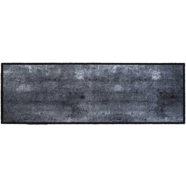 Graue Fußmatte im modernen Design mit einer rechteckigen Form und abgerundetem Rand. Sie liegt flach auf dem Boden und hat eine samtige Oberfläche.
