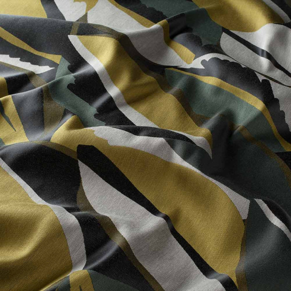 Bunte, gemusterte Textilien zeigen eine Kombination aus Gelb, Grün, Schwarz und Grau in geschwungenen, dynamischen Linien. Der Stoff hat eine strukturierte Oberfläche mit einem modernen Design.