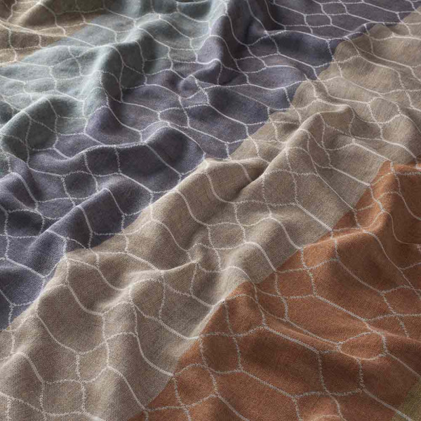 Halbtransparenter Vorhangstoff in verschiedenen Farbtönen – Blau, Beige, Braun und Hellbraun – mit einem eleganten Streifenmuster. Der Stoff liegt sanft und gefaltet auf einer Oberfläche.