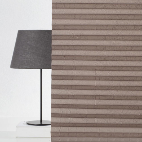 Braunes Plissee in vertikalen Falten, das auf einem weißen Hintergrund liegt. Es zeigt die Struktur und Textur des Materials. Ideal für Sichtschutz und dekorative Zwecke.