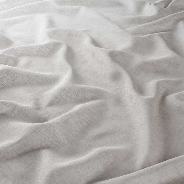 Helle, halbtransparente Gardinenstoffoberfläche in hellgrau liegt zerknittert und geschichtet auf einer Fläche. Die feine Struktur des Stoffes ist sichtbar und wirkt weich und leicht.