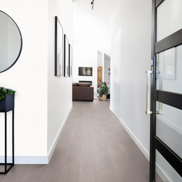 Heller, einfarbiger Vinylboden im Design Soft Oak Silver mit feiner Holzmaserung, in parallelen Planken angeordnet. Der Bodenbelag ist für Innenräume geeignet und verleiht eine elegante Atmosphäre.