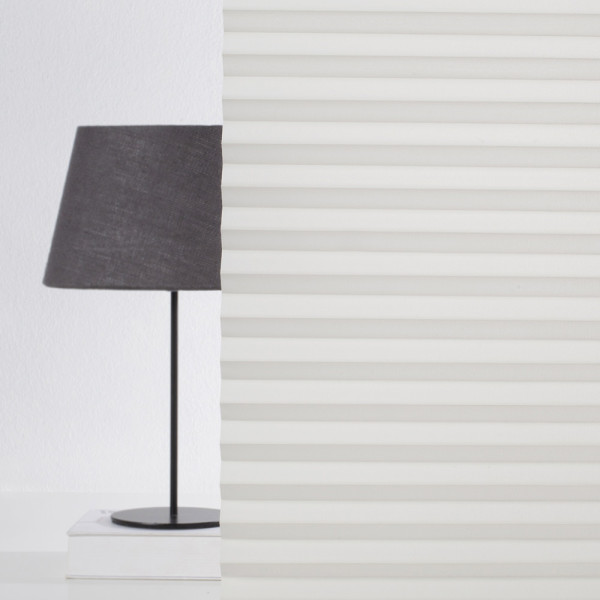Halbtransparentes Plissee, Modell Hannover 8140, liegt in gefalteter Form vor. Die Farbe ist Creme, und das Material wirkt hochwertig und ansprechend.