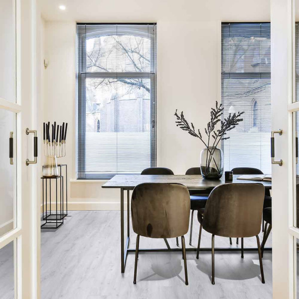 Helle Holzoptik mit sanften, grauen Tönen bildet den Bodenbelag ab. Der stilvolle Designboden wirkt modern und lässt sich vielseitig in Wohnräumen einsetzen.