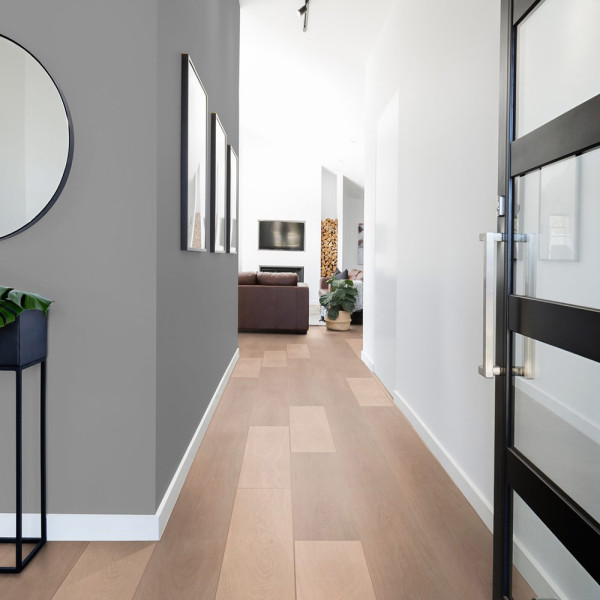 Helle, schlichte Holzoptik mit langen, schmalen Laminatdielen in einem hellen Farbton. Die Dielen sind gleichmäßig angeordnet und vermitteln eine ruhige, moderne Atmosphäre.
