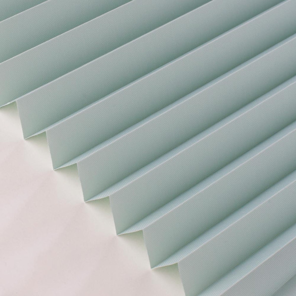 Grüne, gefaltete Plissee-Jalousien zeigen gleichmäßige, senkrechte Falten. Die Struktur sorgt für eine blickdichte Abdeckung und lichtdurchlässigen Effekt. Sie sind auf einem weißen Untergrund angeordnet.