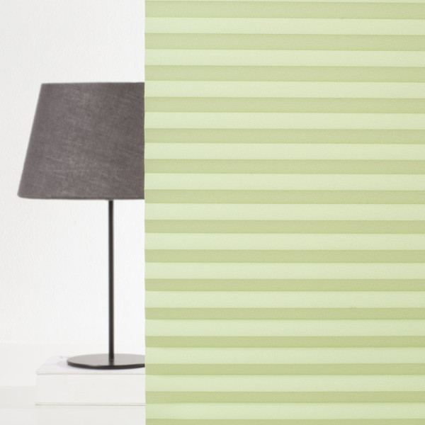 Hellgrünes Plissee mit gefalteter Struktur liegt auf weißem Hintergrund. Es zeigt gleichmäßige Falten, die ein modernes und elegantes Design vermitteln.