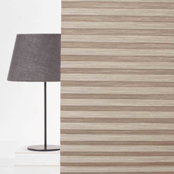 Beige Plissee mit gefaltetem Design liegt auf einer glatten Fläche. Das Material zeigt eine feine, strukturierte Oberfläche, die elegant und modern wirkt.