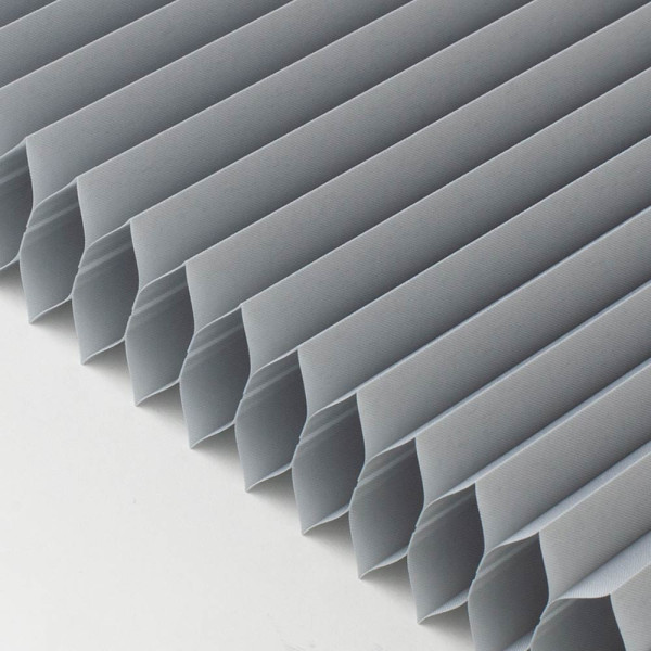 Grau gefaltete Wabenplissees sind in gleichmäßigen Abständen angeordnet. Die Struktur zeigt die Falten und das hochwertige Material, das in maßgeschneiderte Produkte eingesetzt wird.