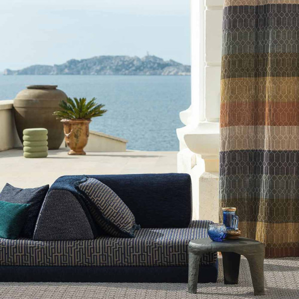 Halbtransparenter Vorhangstoff in verschiedenen Farbtönen – Blau, Beige, Braun und Hellbraun – mit einem eleganten Streifenmuster. Der Stoff liegt sanft und gefaltet auf einer Oberfläche.